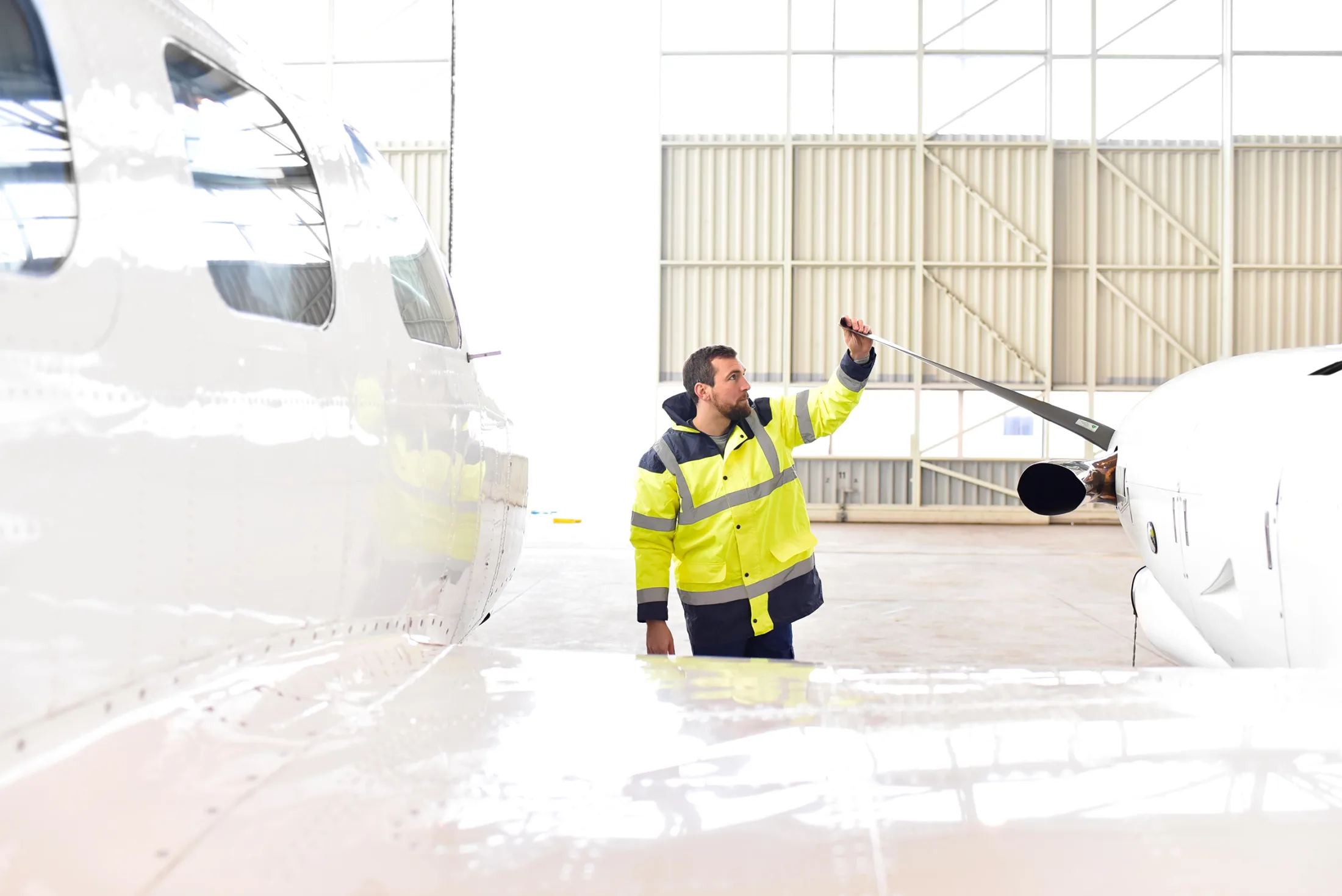 A Clipper Aviation technician inspecting a propeller blade in the hangar