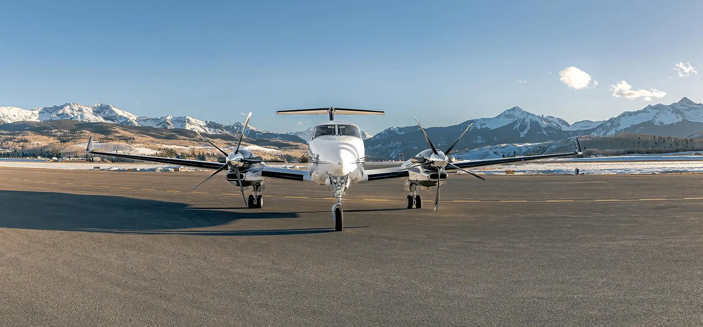 A King Air 350 photographed head-on at a mountain airfield