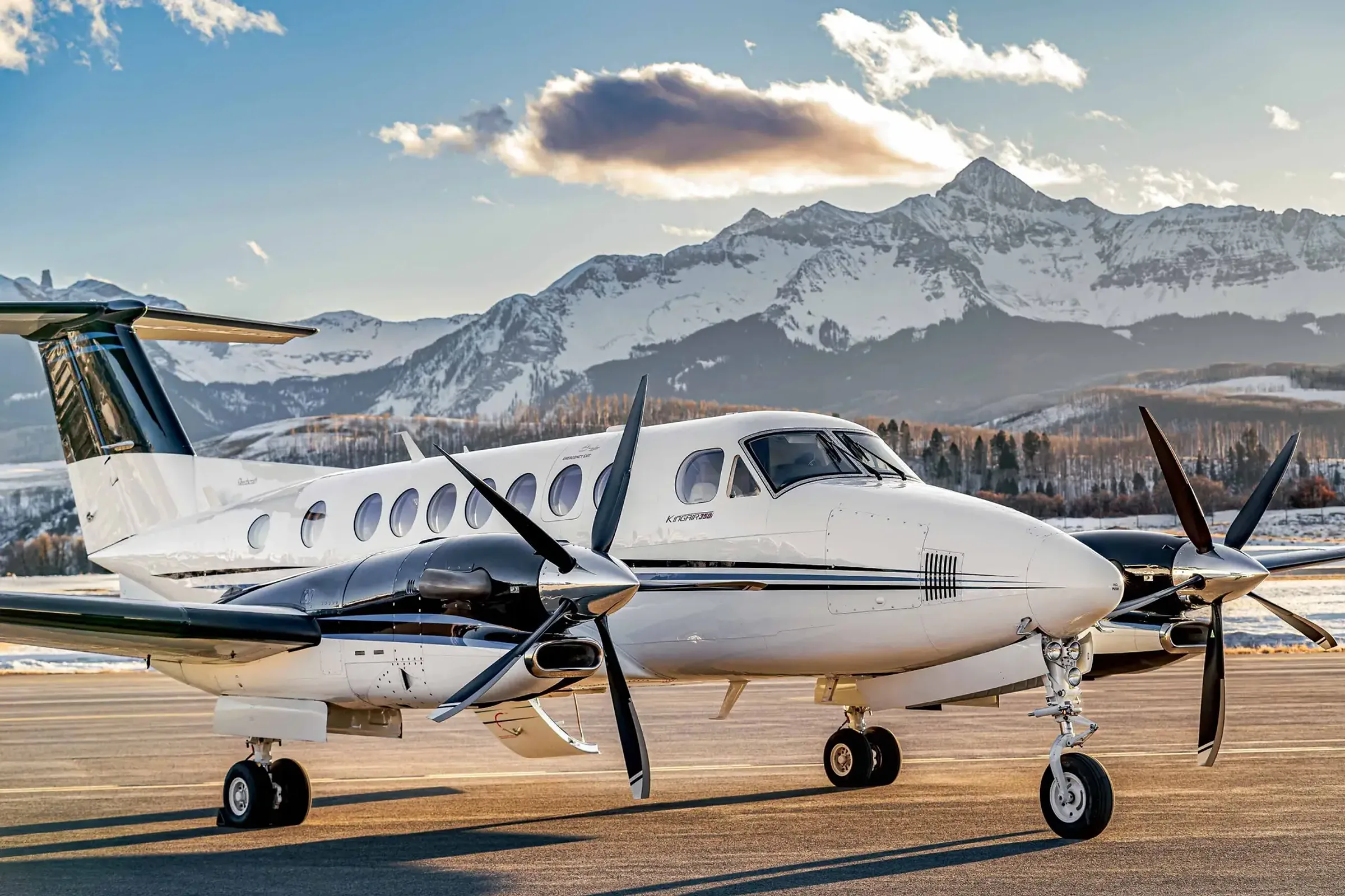Clipper Aviation King Air 350 on the ramp at golden hour with snow-covered mountains behind